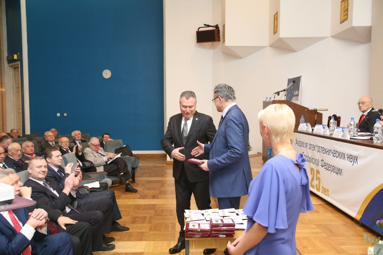 AES RF President Pavel Butyrin is handing the Medal of Merit for Electrical Engineering to Alexander Slavinsky