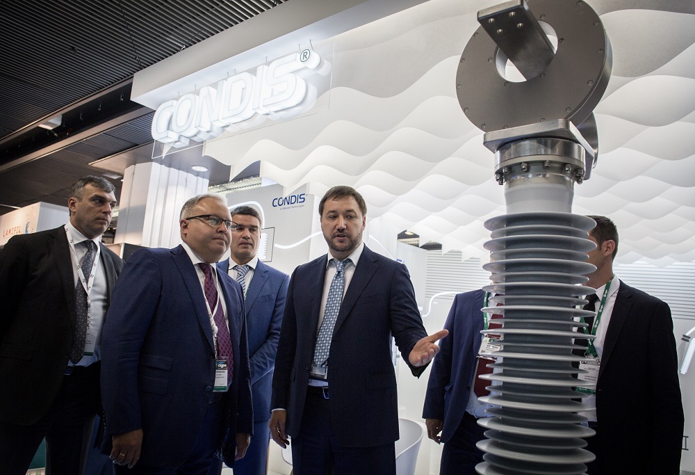 Andrey Murov (2nd on L) is  getting familiar with the power equipment, exhibited at the 47th CIGRE session (photo: FGC UES)