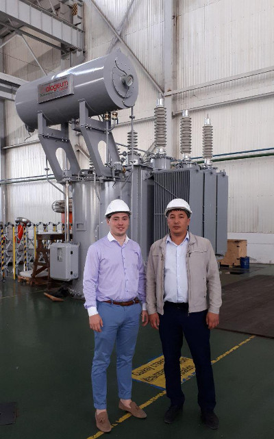 Dmitry Karasev (L) and Purchasing Specialist at KTP Maksat Kurmanaliev by a KTP transformer with Izolyator HV bushings