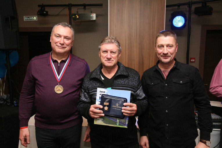 The badge of merit “For longstanding and dedicated work” at Izolyator is awarded to Alexander Bogatyrev (center)