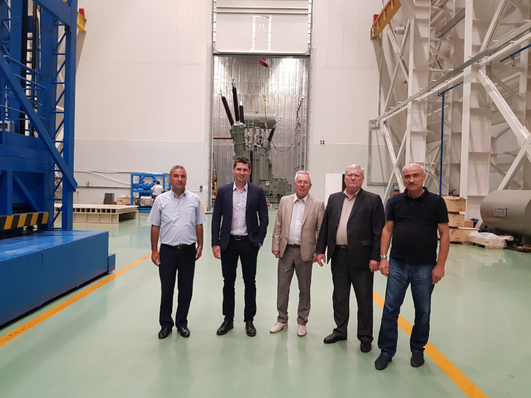 Plant tour for Izolyator plant representatives at Power Transformer Manufacturing Plant, part of ATEF Group, L-R: Process engineer Subhan Jafarov, Maxim Zagrebin, Victor Kiryukhin, Deputy Chairman of the Board of Directors at ATEF Group Nikolay Molodetsky and Chief of Assembly shop Abas Abasov. In the forefront — 330 kV transformer with Izolyator bushings