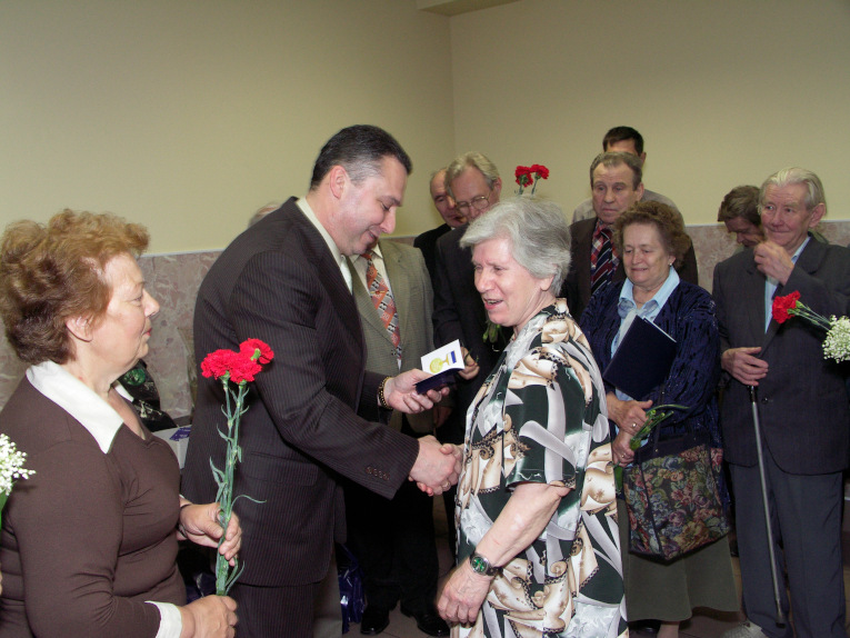 Nelya Efimovna hands flowers to the veterans of the Izolyator plant at the celebration of the 110th anniversary of the enterprise in 2006