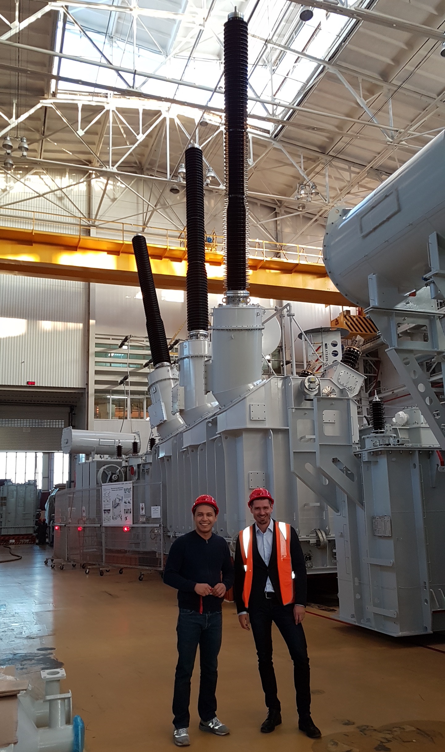 Purchasing manager at SVEL — Power Transformers Danila Safin (L) and Maxim Zagrebin at SVEL — Power Transformers in Ekaterinburg. At the background — a 265 MVA transformer with 550 kV Izolyator bushings, made for RusHydro Group